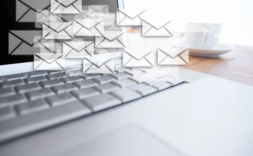 Tela de computador com ícones de envelopes representando e-mails sobre o teclado, simbolizando e-mail marketing e fluxo de mensagens eletrônicas